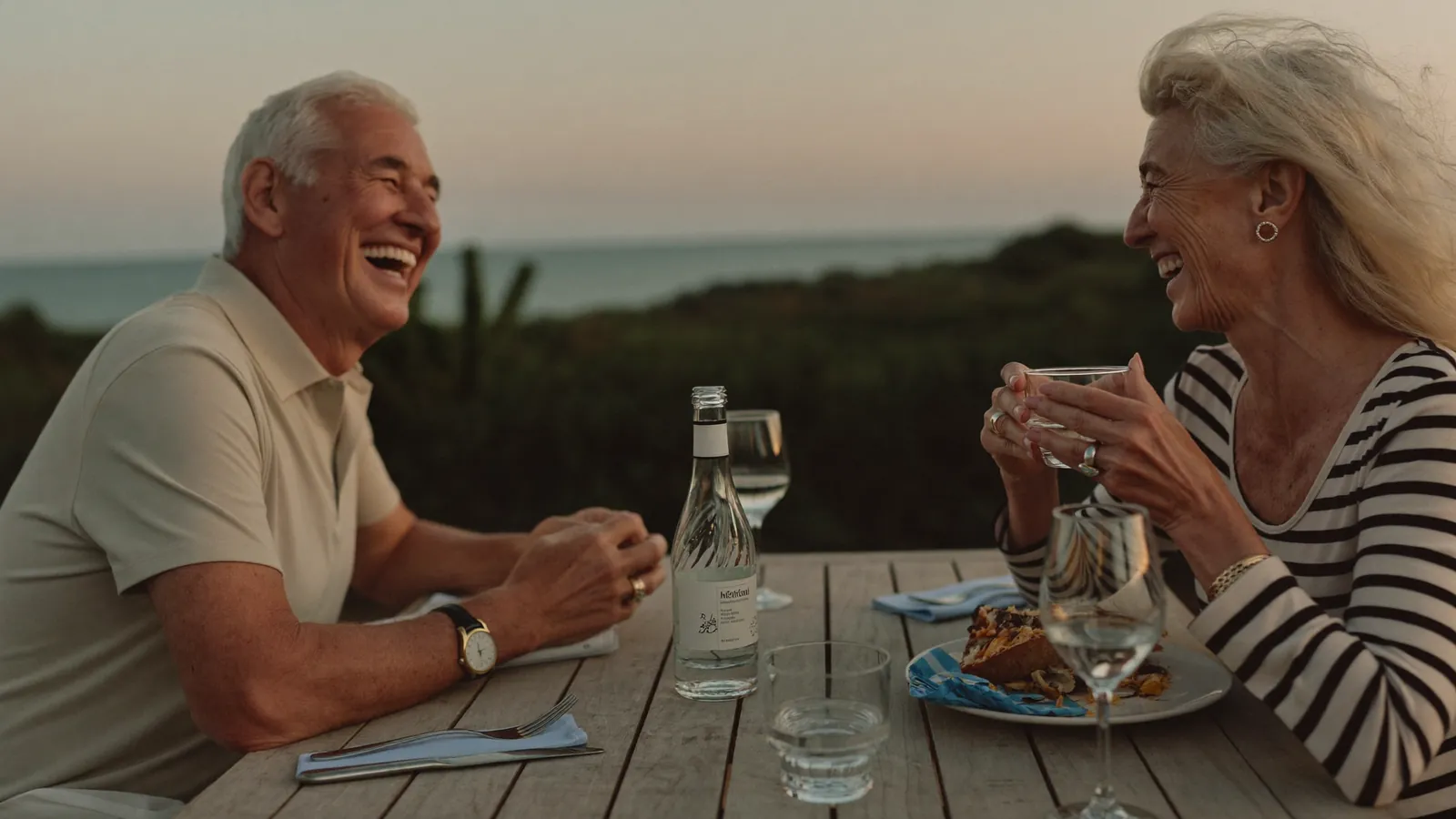 A couple at dinner at an outdoor table at dusk